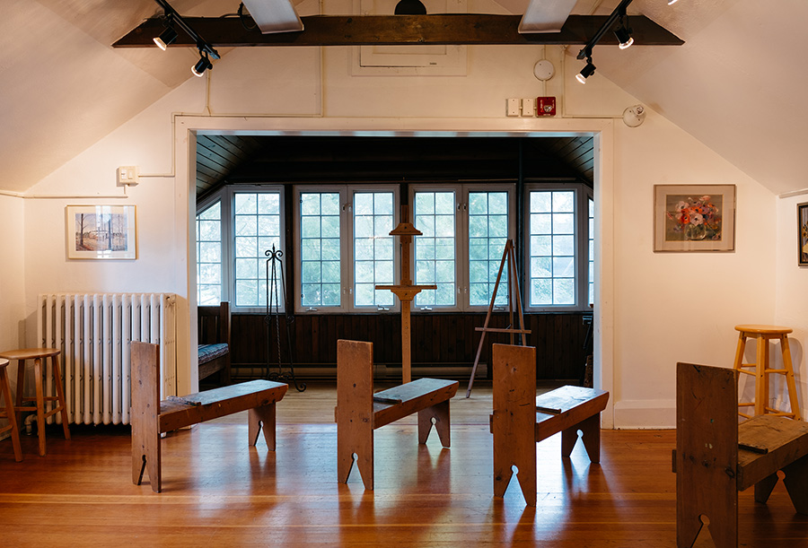 Donkey easels in the foreground of a space with cathedral ceilings and windows in the distance.