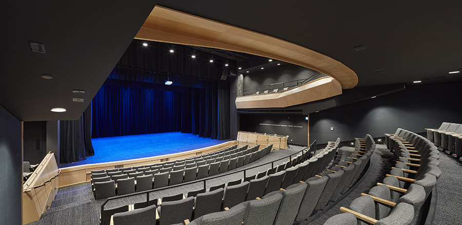 Looking towards the stage of a theatre with multi-level seating arranged in a semi-circular pattern.