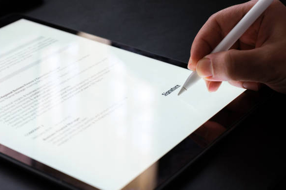 Close up of a hand signing a digital contract