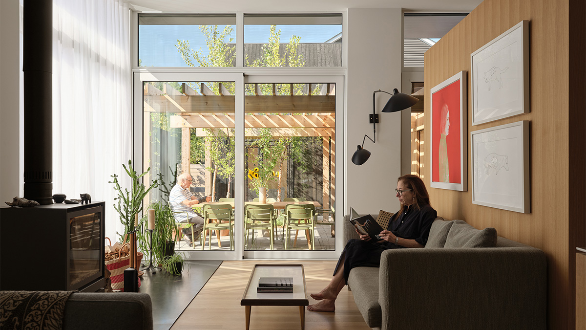 A bright living room with large glass doors opening to a sunlit patio