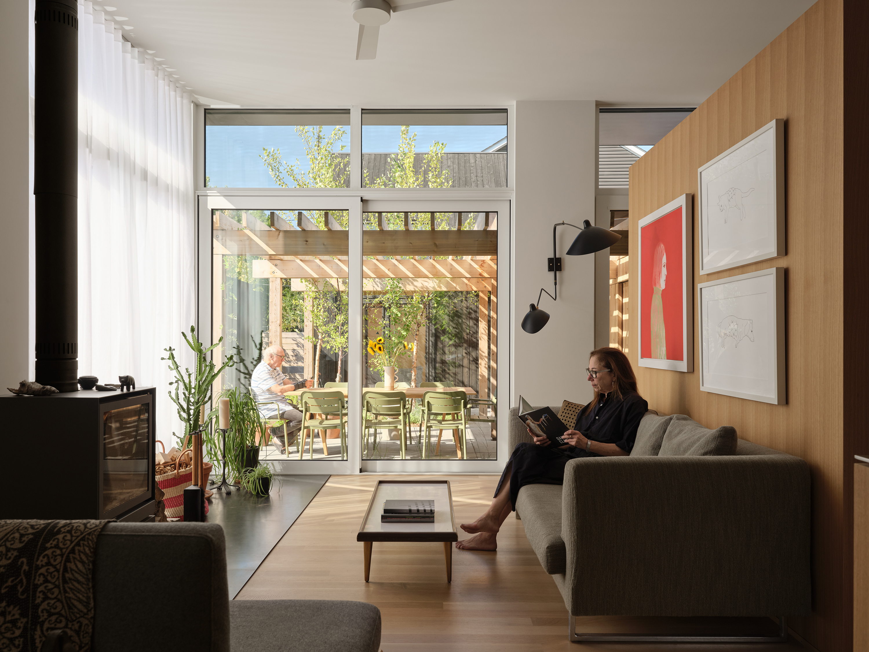 A bright living room with large glass doors opening to a sunlit patio