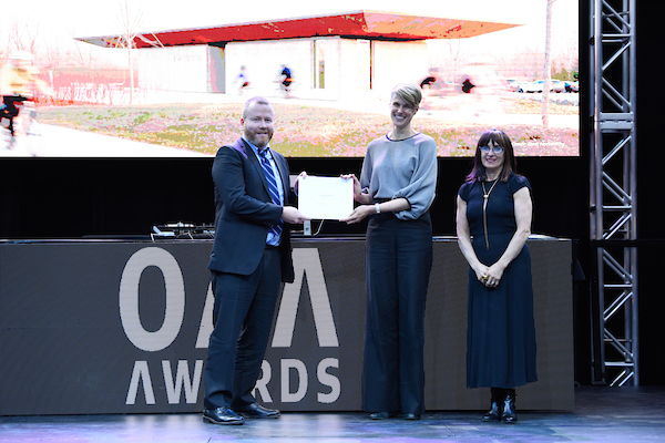 Image of Megan Torza and Charles Mackintosh  accepting the award