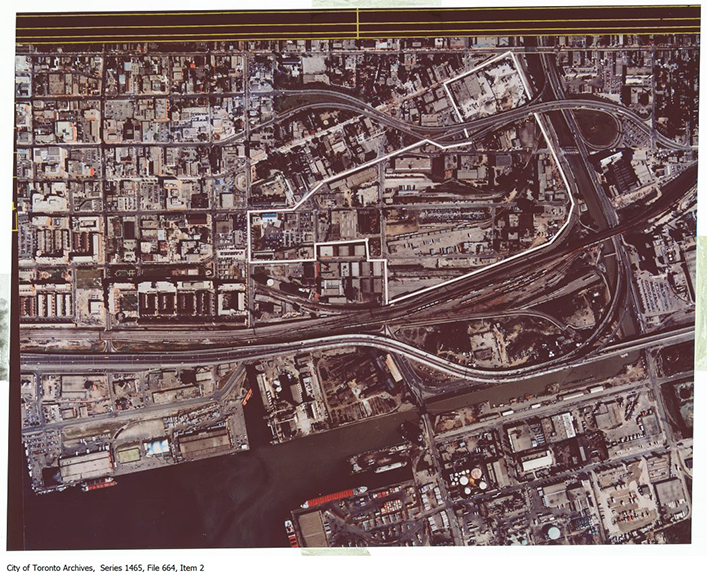 Warm-toned aerial image showing the Lower Don River along the right and the Keating Channel along the bottom. The land around the West Don Lands is surrounded by a series of railway lines.