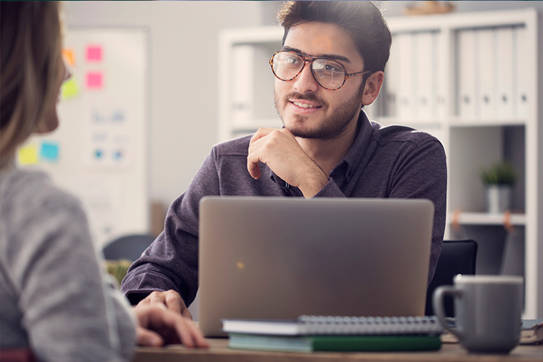 two people taking in front of a laptop