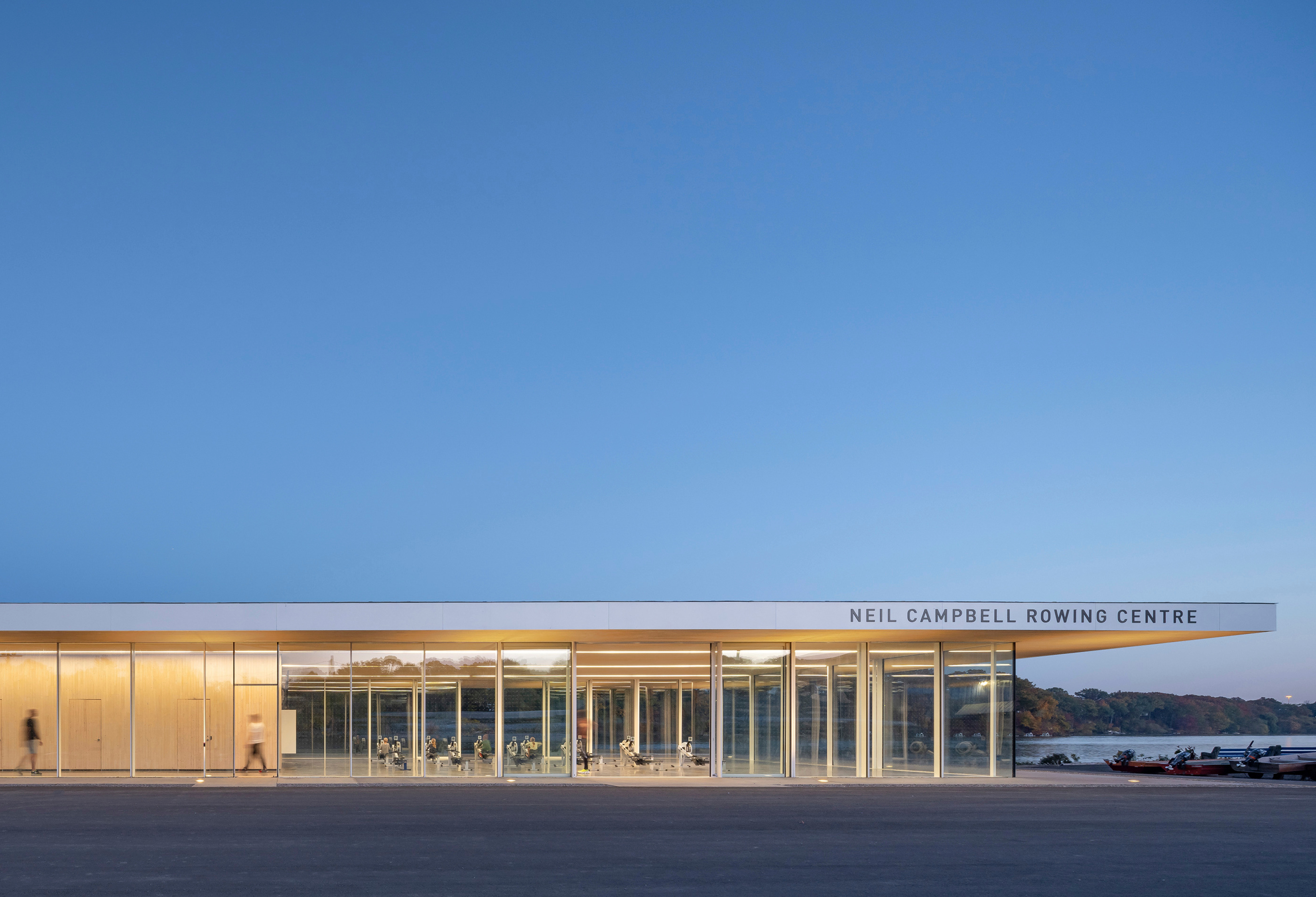 The large, planar roof of the Neil Campbell Rowing Centre stretches out beyond the building to create generous overhangs.
