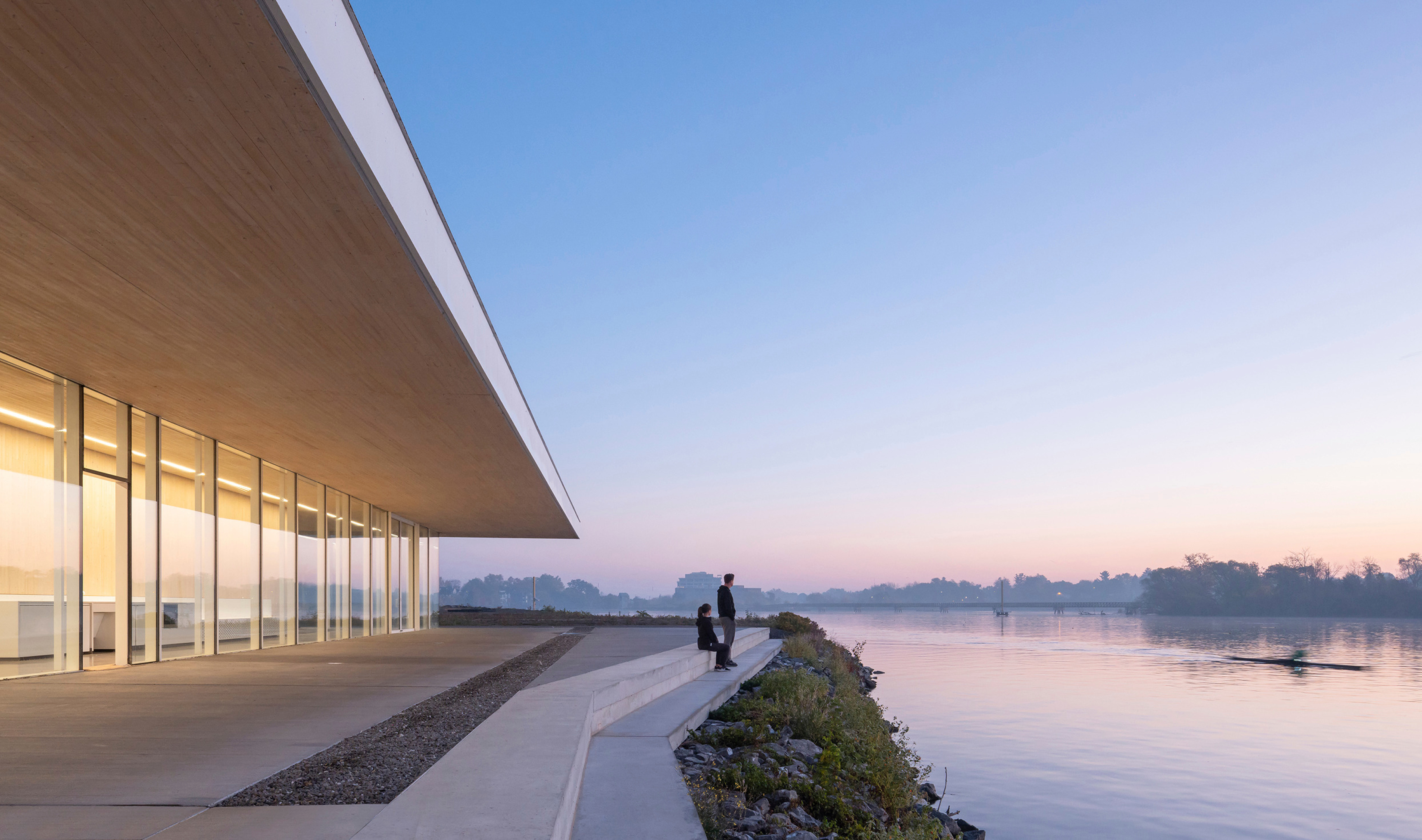 New concrete steps connect the rowing centre to the water, with a serene waterfront view.