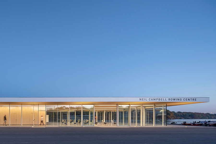 The large, planar roof of the Neil Campbell Rowing Centre stretches out beyond the building to create generous overhangs.