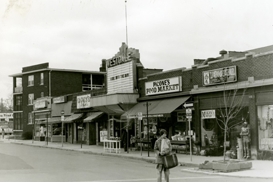 Historic black-and-white image of the Westdale Theatre, featuring its original marquee and surrounding commercial buildings.
