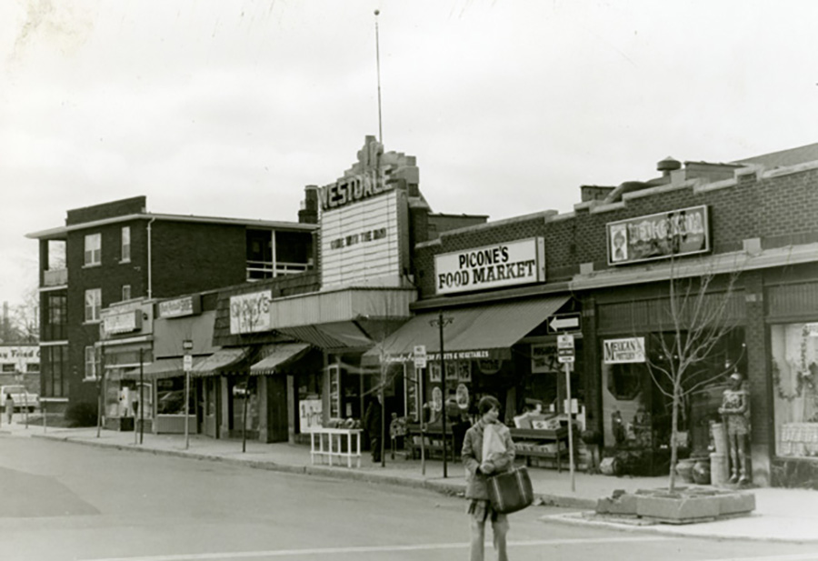 Historic black-and-white image of the Westdale Theatre, featuring its original marquee and surrounding commercial buildings.