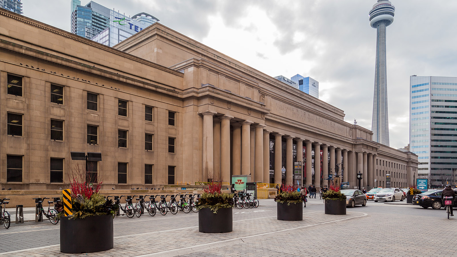 A grand limestone building with large doric columns and classical decorative elements.